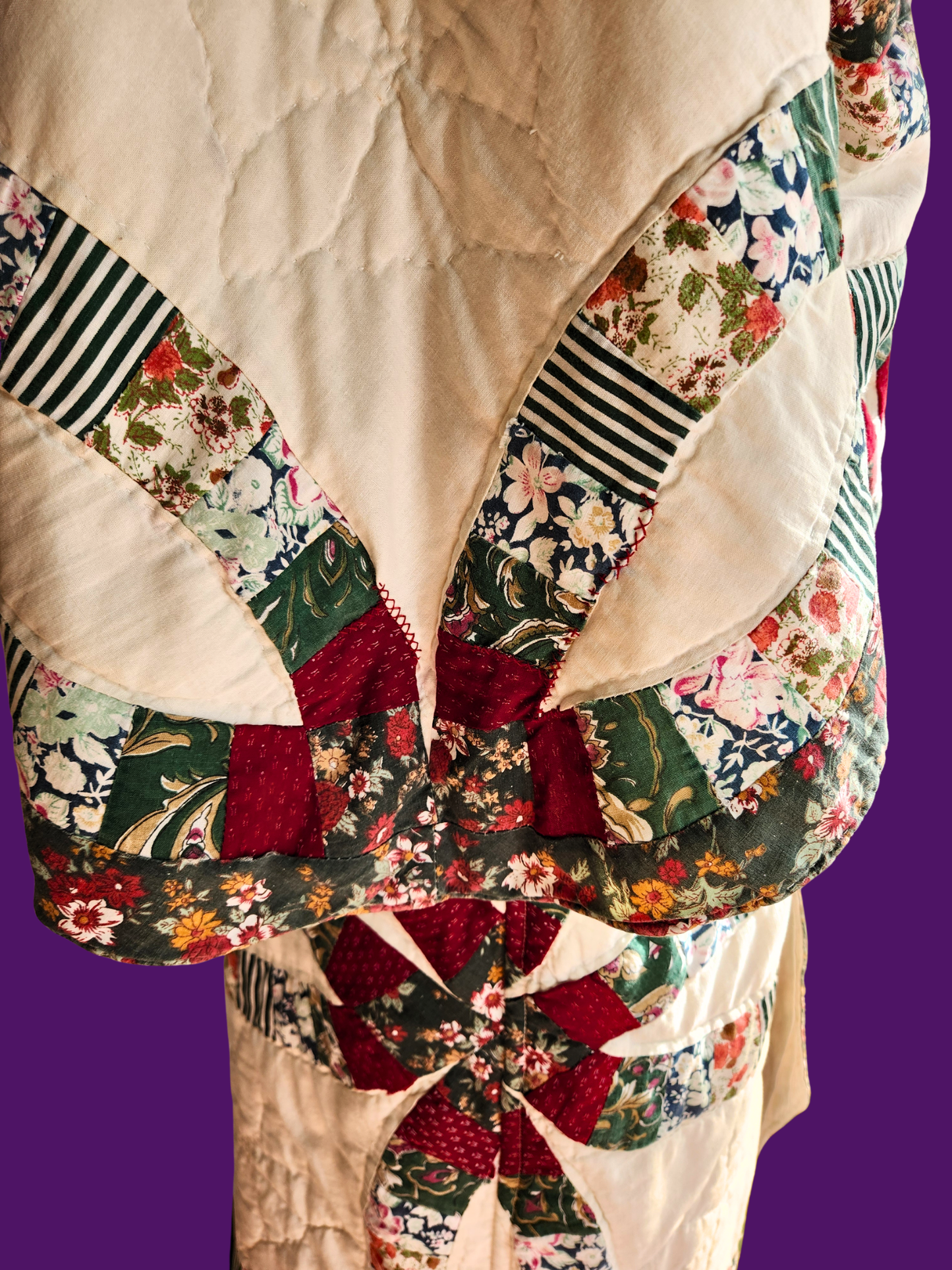 Patchwork quilt with floral and striped patterns on a purple background