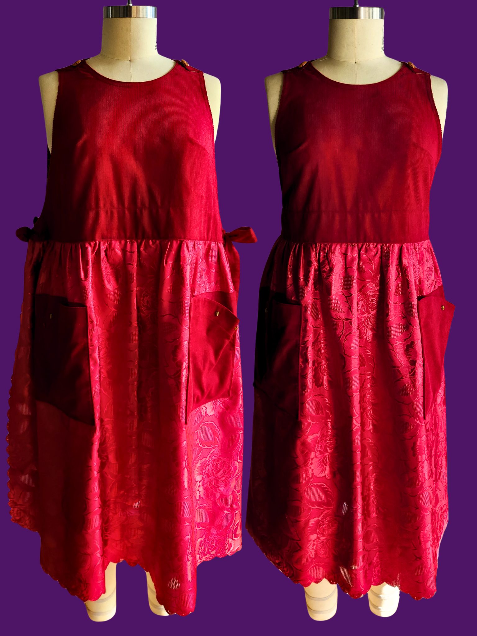 Two red dresses on mannequins against a purple background