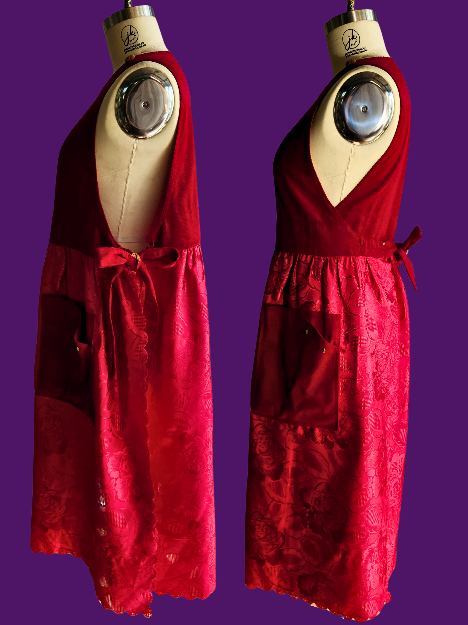 Two red dresses on mannequins against a purple background