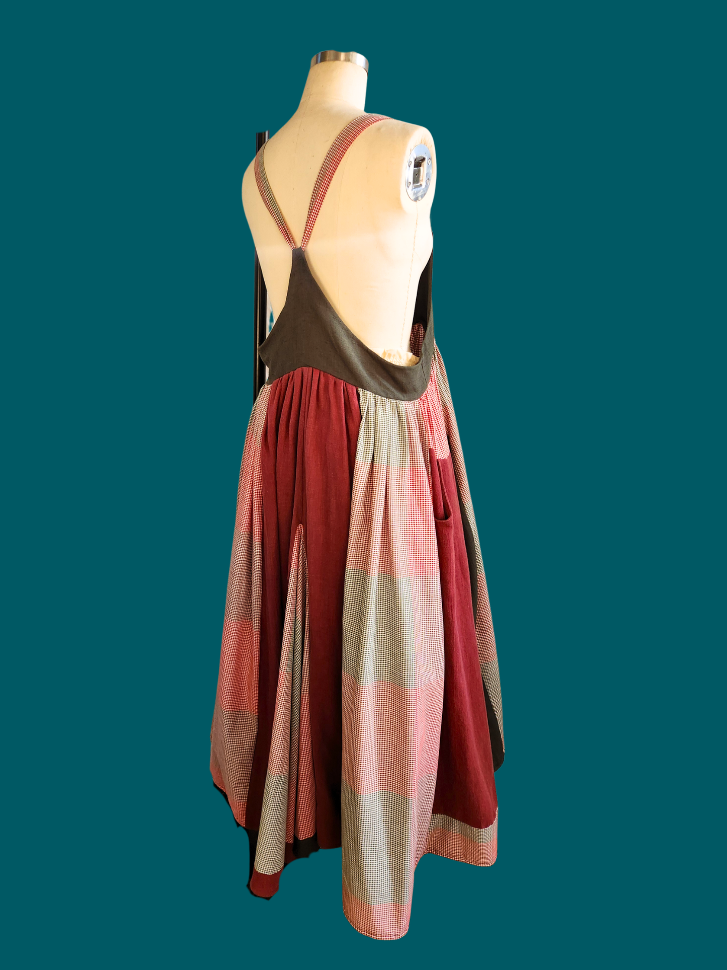 Colorful dress on a mannequin against a teal background