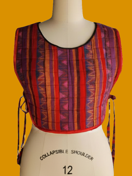 Colorful striped top on a mannequin against an orange background