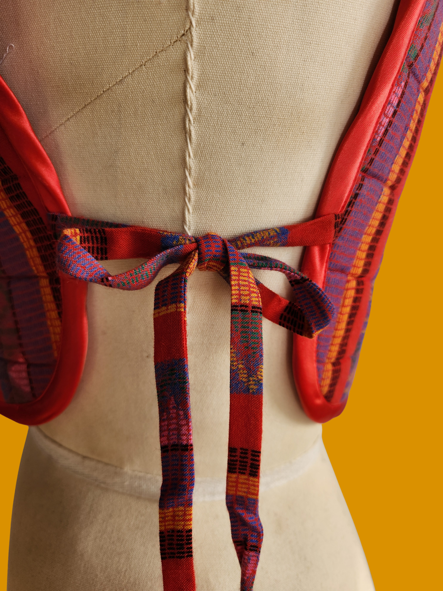 Colorful backpack straps on a beige backpack against a yellow background
