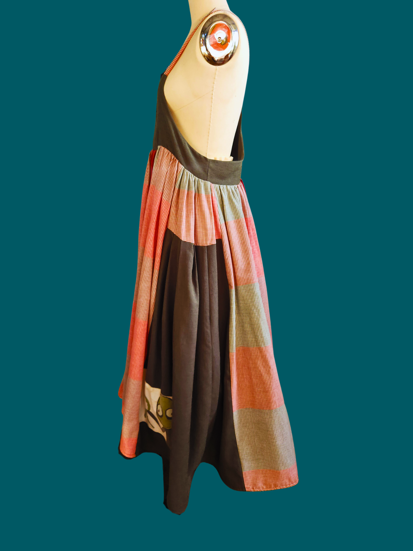 Colorful dress on a mannequin against a teal background