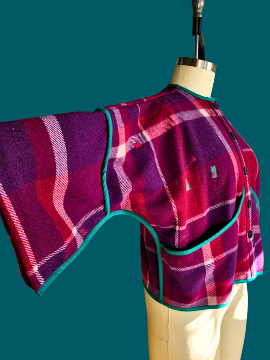 Plaid-patterned garment on a mannequin against a teal background