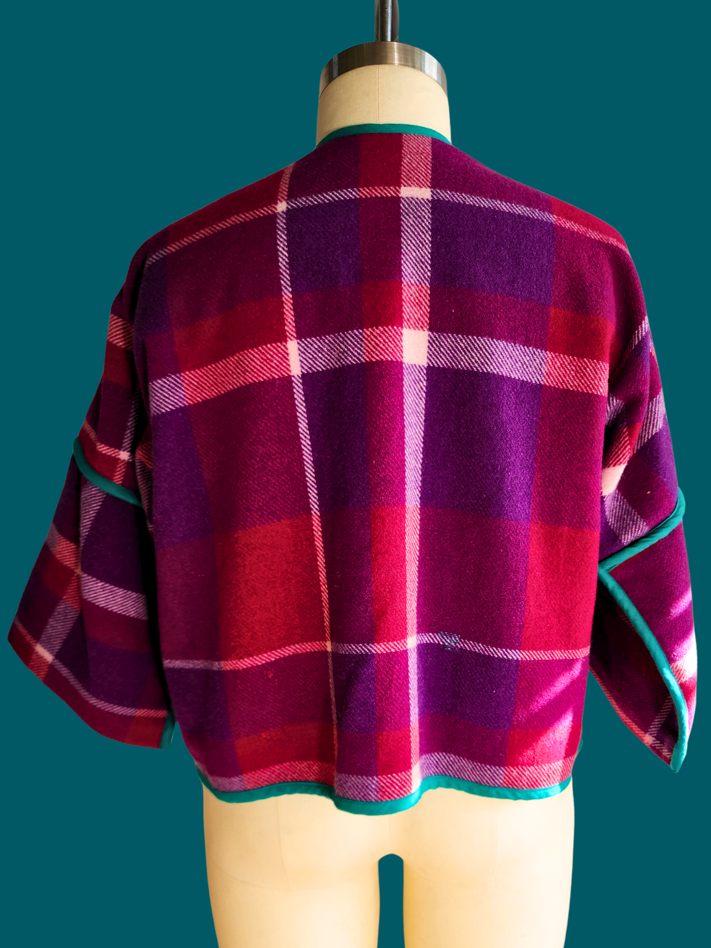 pink plaid jacket on a size 18 model on a teal background