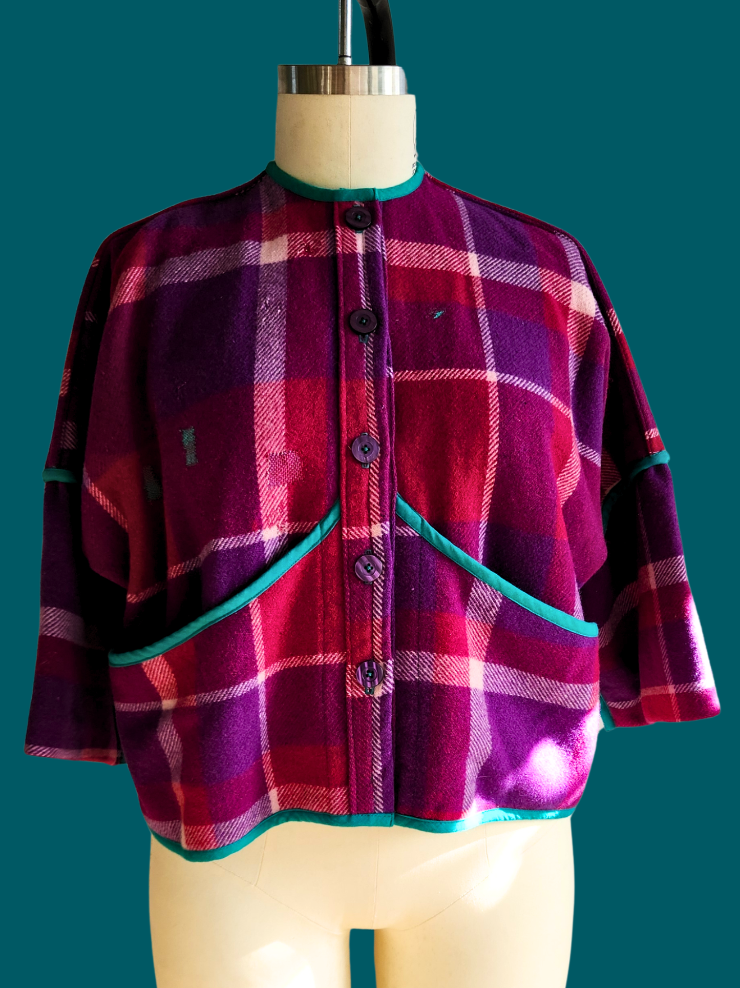 pink plaid jacket on a teal  background with buttons on a size 18 model