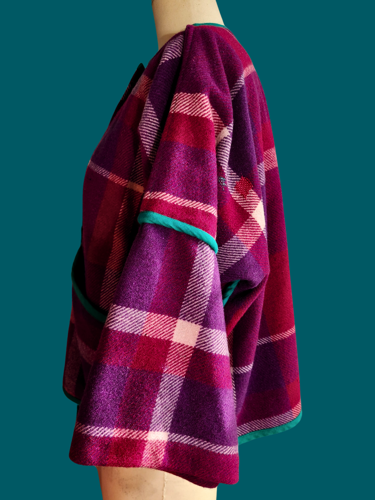 left side of pink plaid jacket on size 12 model on a teal background
