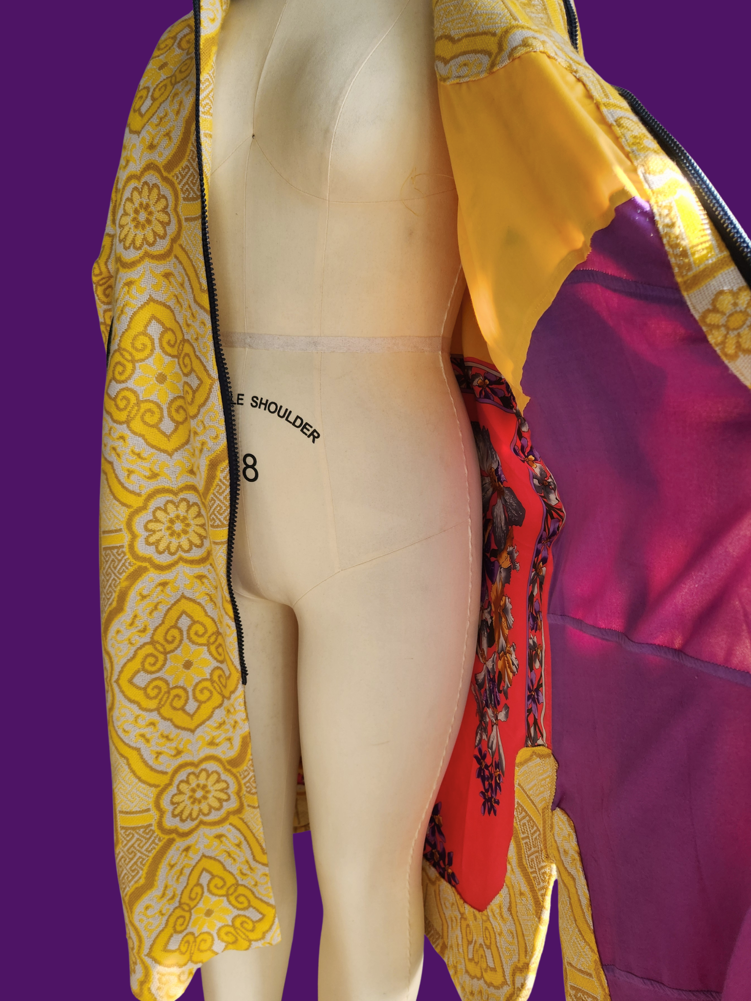 Mannequin wearing a colorful patterned garment on a purple background