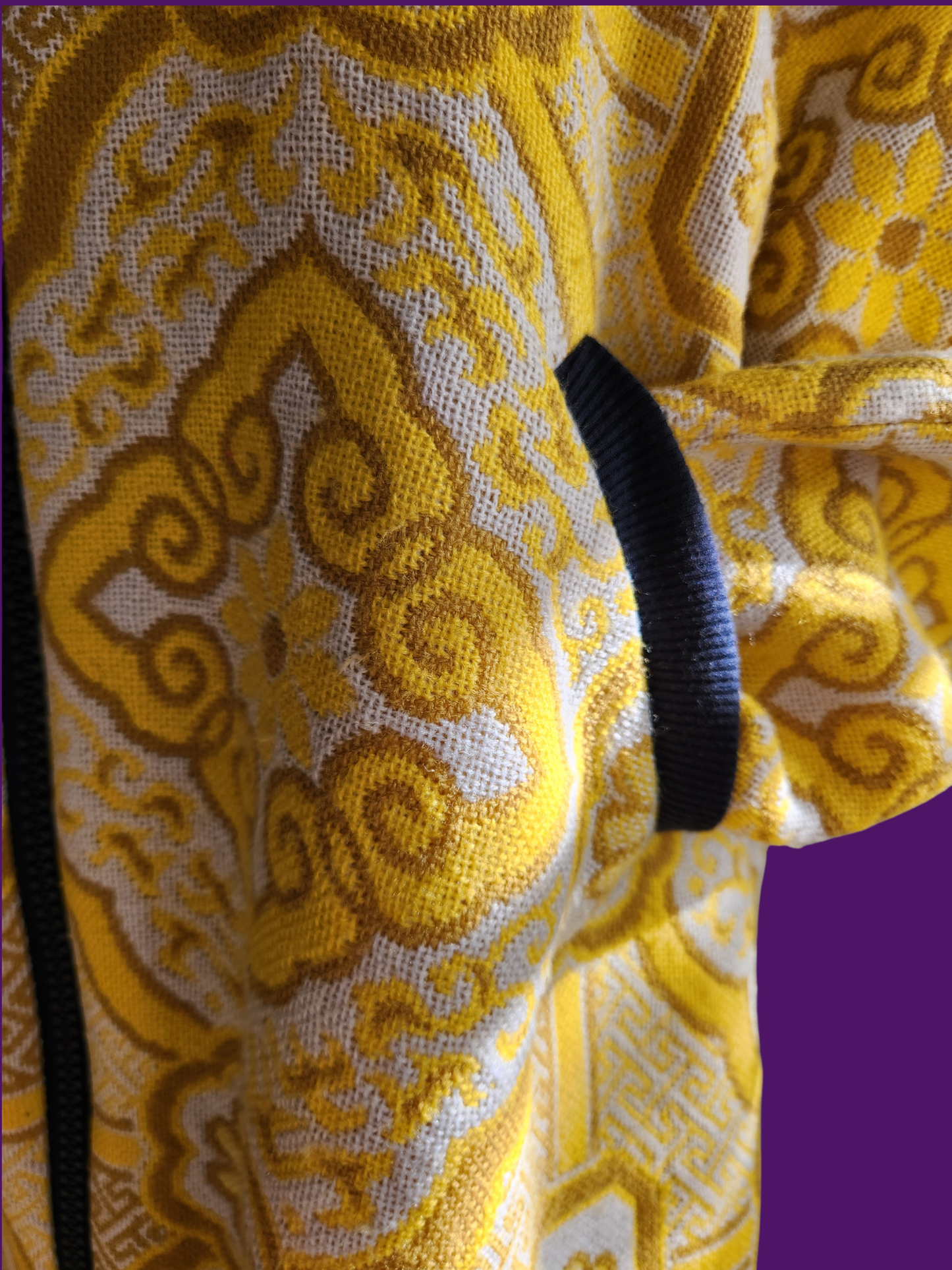 Close-up of a yellow and white patterned fabric with a black trim.