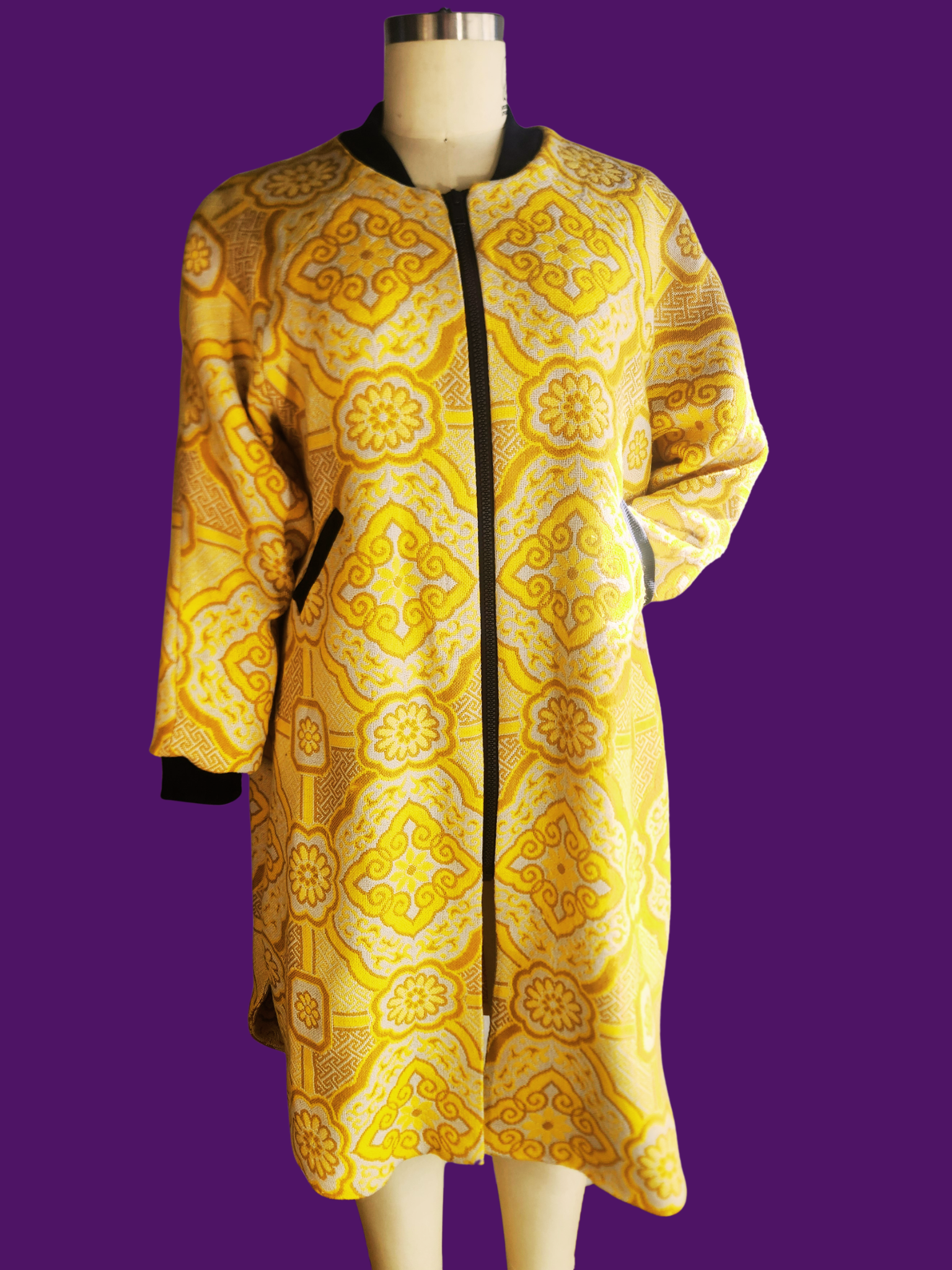 Yellow patterned coat on a mannequin against a purple background