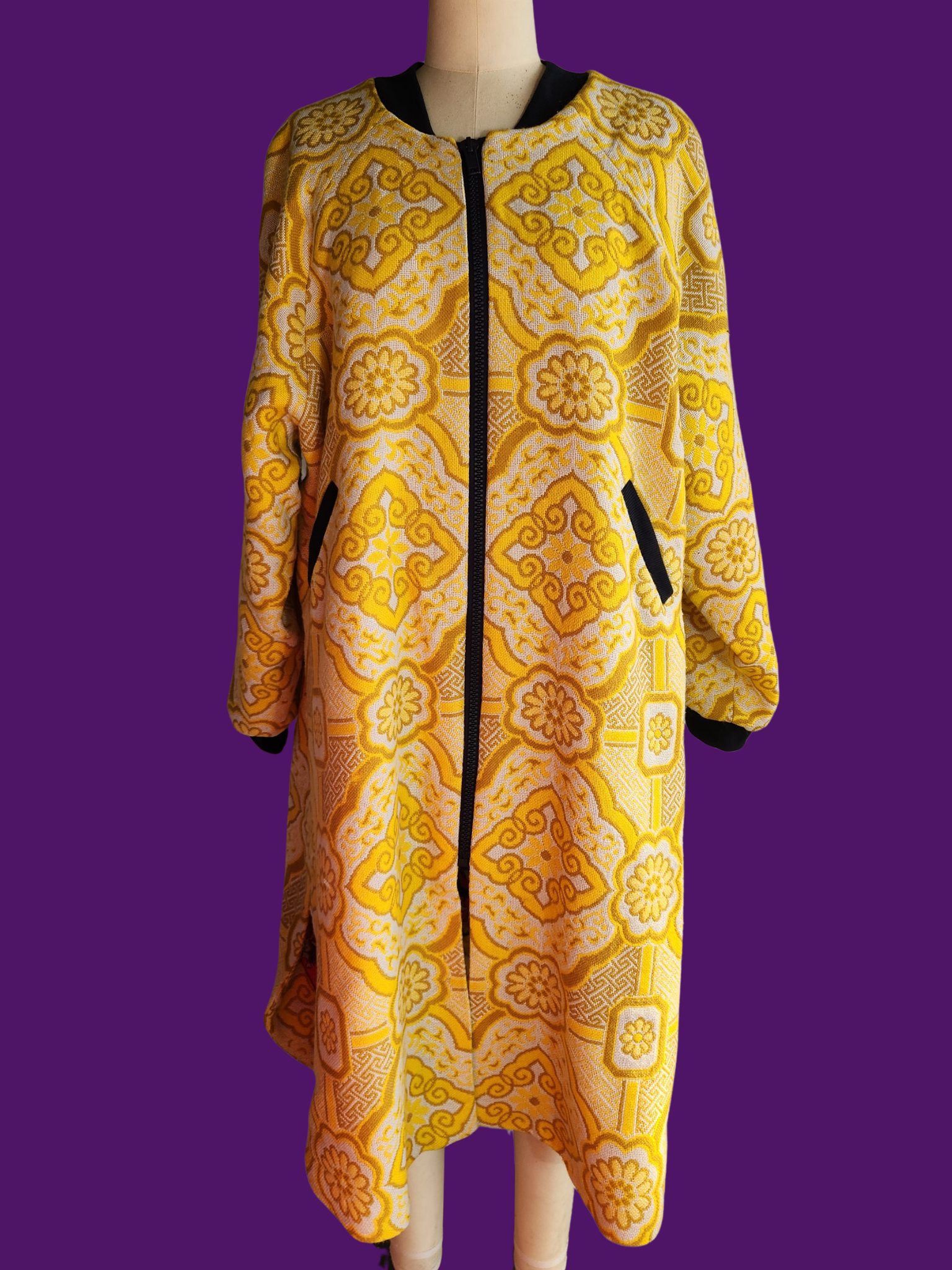Yellow patterned coat on a mannequin against a purple background