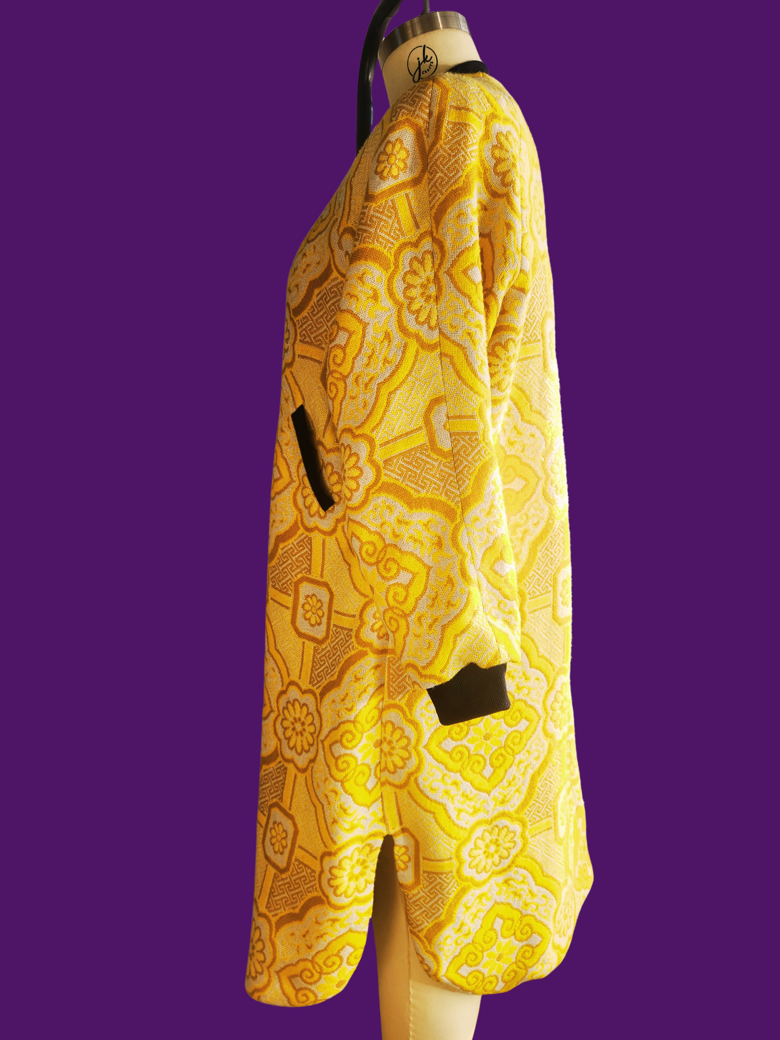 Yellow patterned garment on a mannequin against a purple background