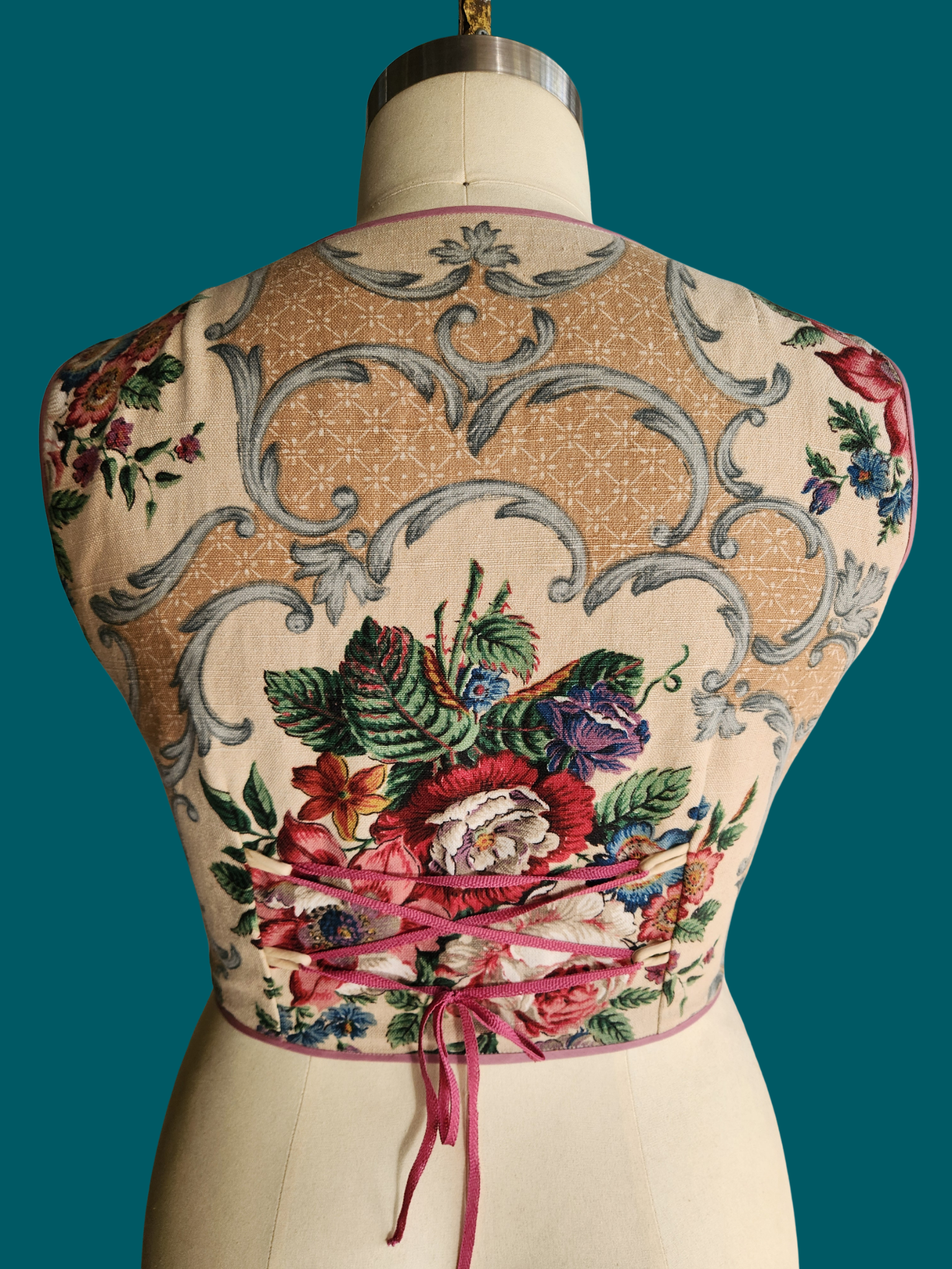 floral top on a mannequin against a teal background