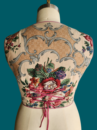 floral top on a mannequin against a teal background