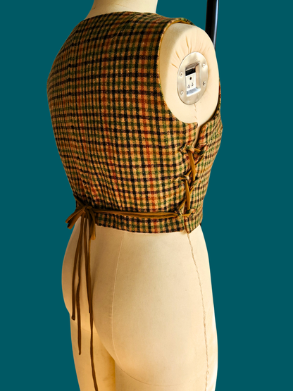 Mannequin wearing a plaid top and beige pants against a teal background