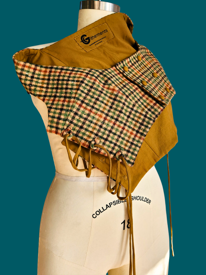Mannequin wearing a mustard yellow jacket with a plaid collar against a teal background