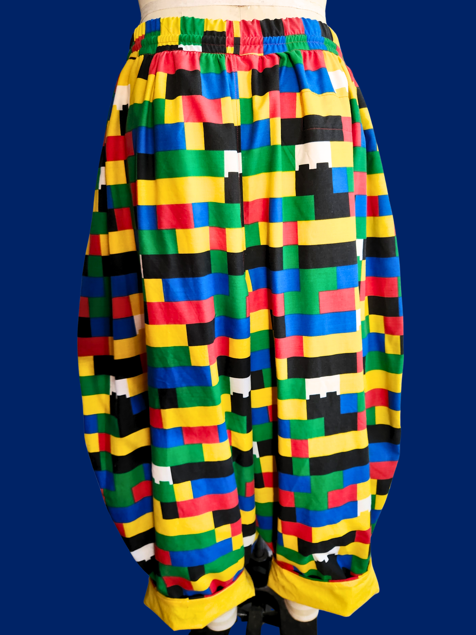 Colorful checkered skirt on a mannequin against a blue background