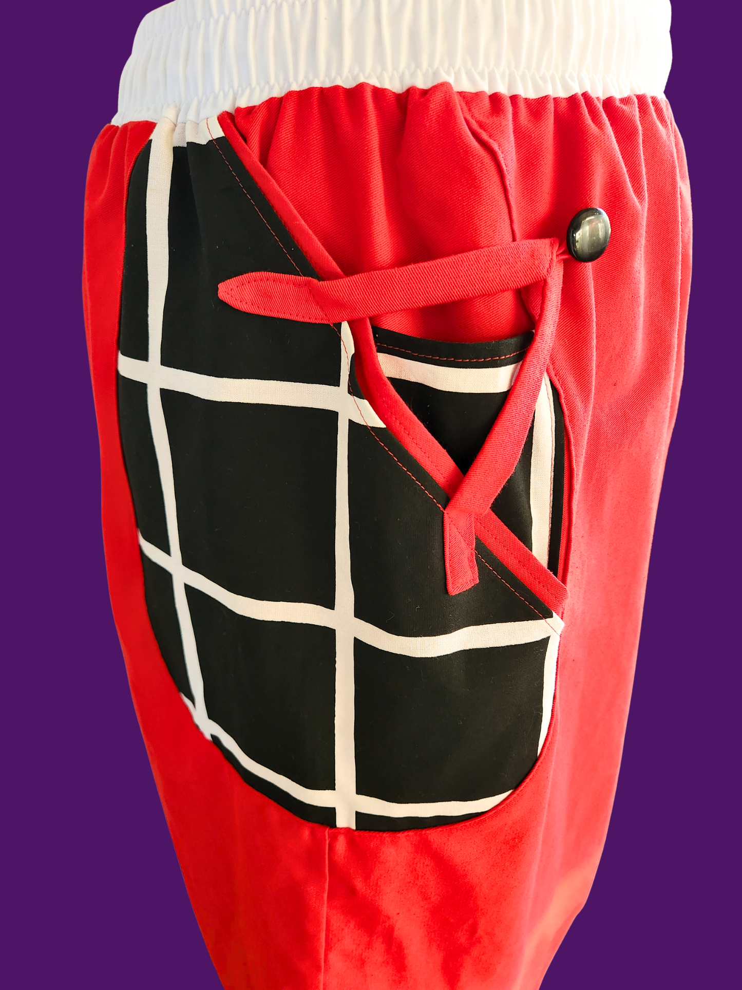 Red pants with a black and white grid pattern on a purple background