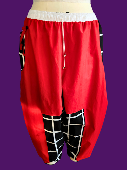 Red baggy pants with black and white checkered patterns on a purple background