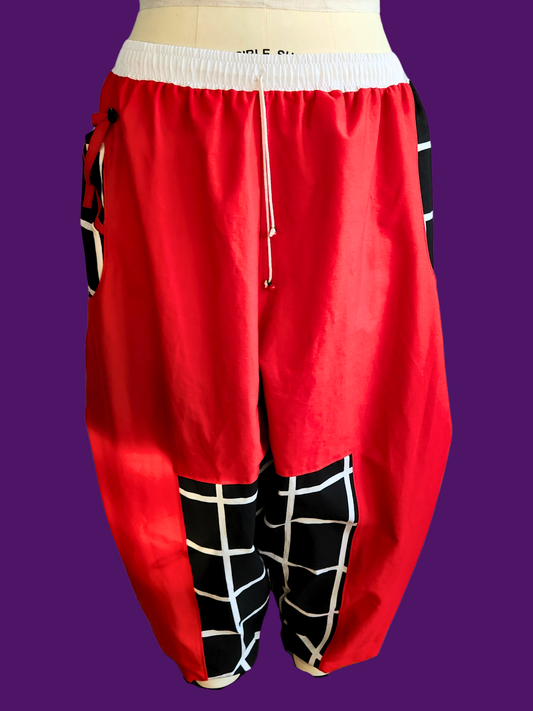 Red baggy pants with black and white checkered patterns on a purple background