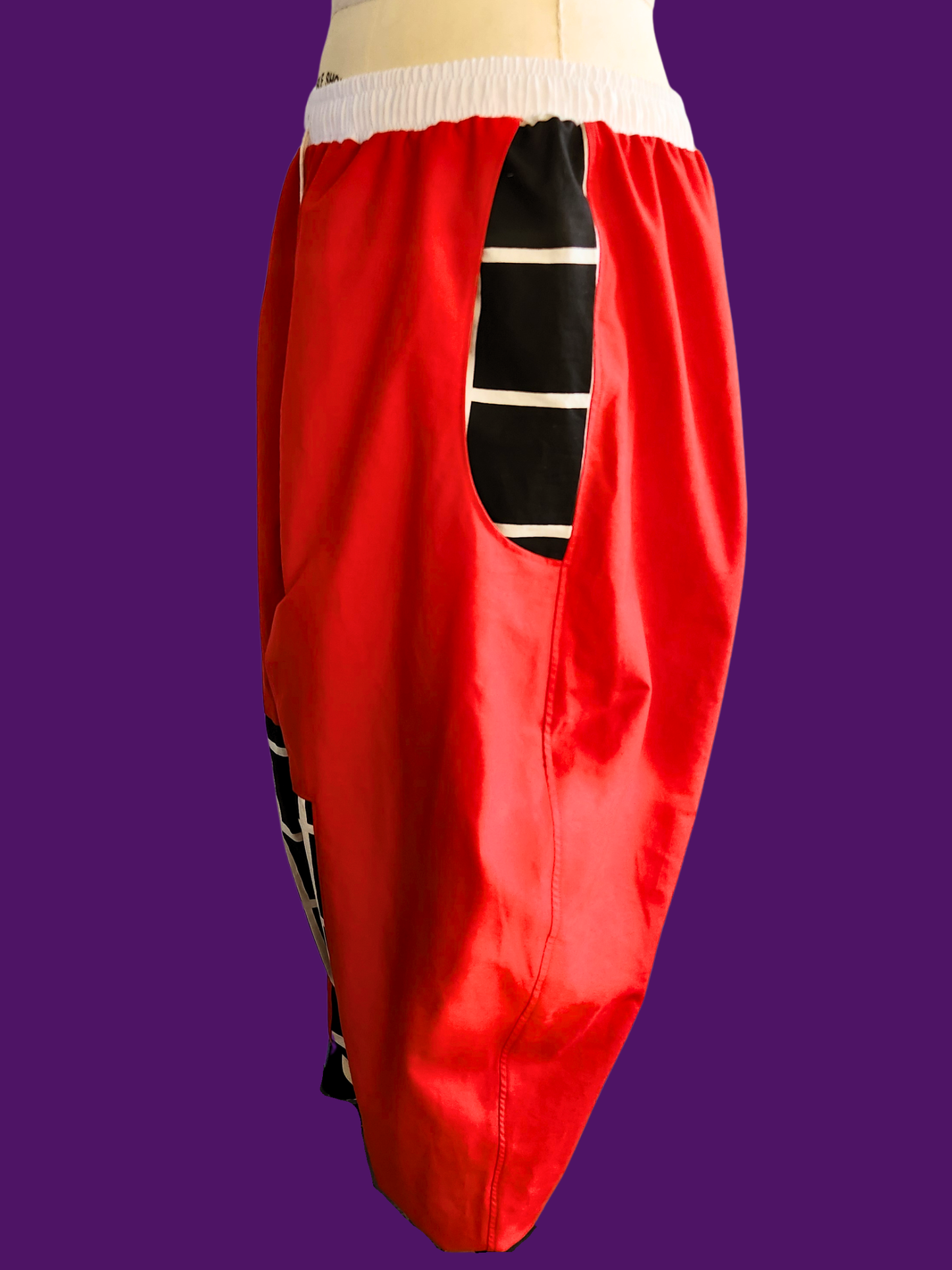 Red pants with a black and white striped pattern on a purple background