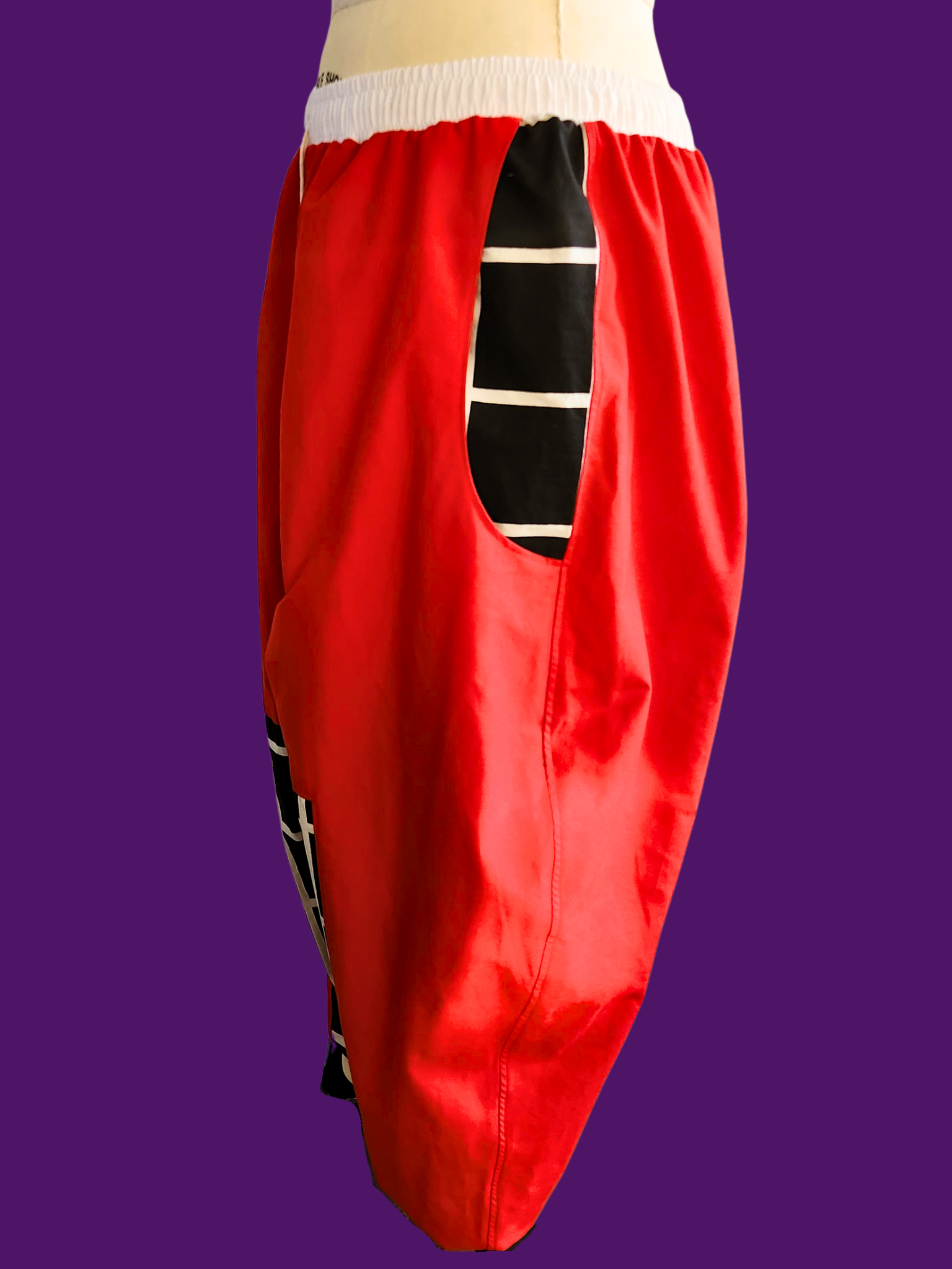 Red pants with a black and white striped pattern on a purple background